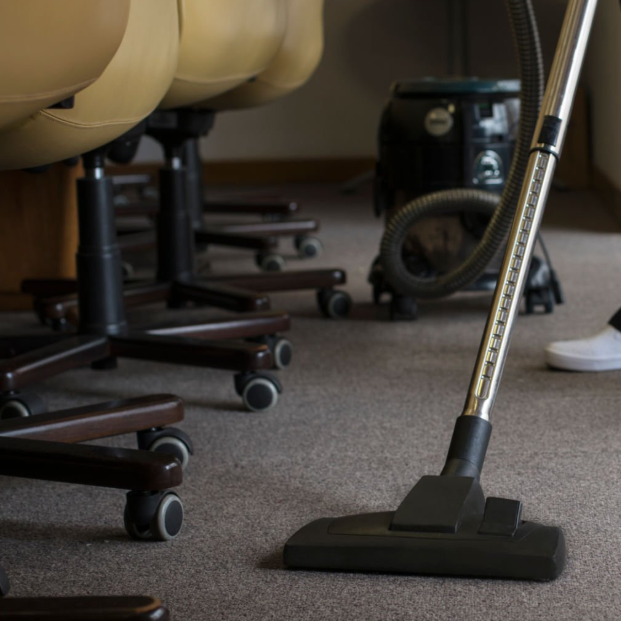 Aspirateur sur moquette à côté de chaises de bureau.