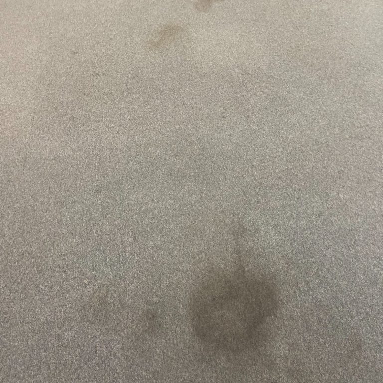 Surface grise avec des taches irrégulières visibles.